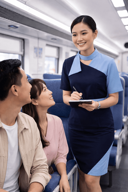 pramugari sedang menunjukkan Skill Wajib Pramugari Kereta yang Bikin Kamu Mudah Diterima Kerja